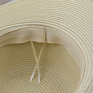 Inside view of beige bohemian straw hat featuring adjustable sweatband drawstring detail