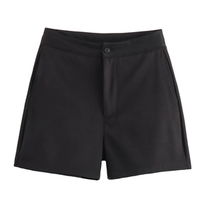 Détail d'un short noir minimaliste avec fermeture à bouton et tissu lisse et fluide
