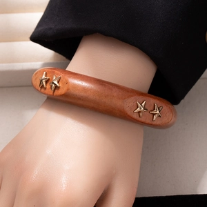 Retro wide wood bangle with gold star inlay on model for a vintage fashion style
