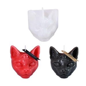 Three-eyed cat silicone mold with finished black and red handmade aroma candles