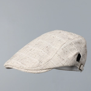 Détail de la boucle métallique et de la texture en tweed sur la casquette plate beige