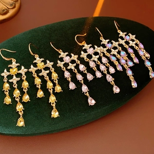 Detailed view of vintage star and heart tassel earrings in yellow, pink, and purple