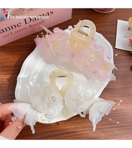 Detail of pink and white lace butterfly hair claws with pearls and rhinestones on a tray