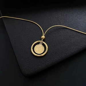 Vue macro d'un pendentif Fu doré avec motif traditionnel chinois sur fond noir mat