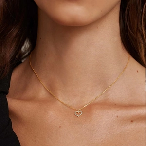 Close-up of model wearing a gold S925 silver heart necklace with sparkling pavé diamonds