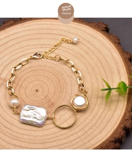 Detail of baroque pearl bracelet with gold chain, lobster clasp, and natural iridescent finish