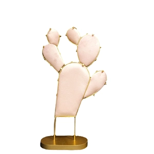 Pink velvet cactus jewelry display stand with golden metal frame and oval base