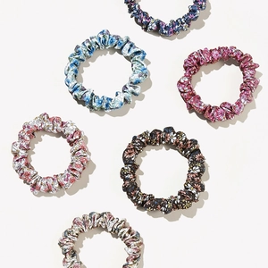 Set of six floral print scrunchies in various colors like blue and pink on a clean background
