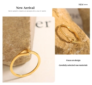 Detail shot of a minimalist gold cutout ring resting on a textured natural stone base