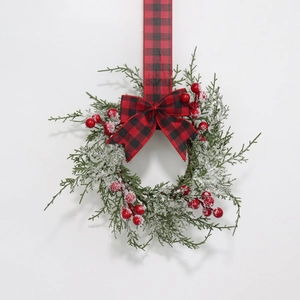 Christmas wreath with cypress branches, red berries and buffalo plaid bow on white