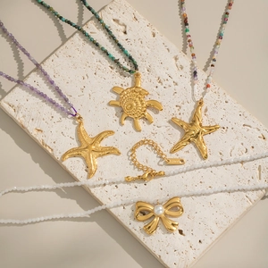 Detailed shot of ocean-themed beaded necklaces with starfish, shells and bow pendants