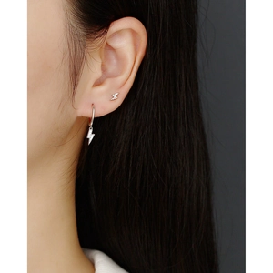 Macro view of S925 sterling silver lightning bolt earrings with pavé zircons on model