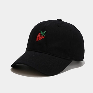 Close-up of the detailed strawberry embroidery on a black cotton baseball cap fabric