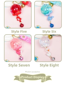 Macro detail of four creative oil-filled wind chime keychains with charms and bells