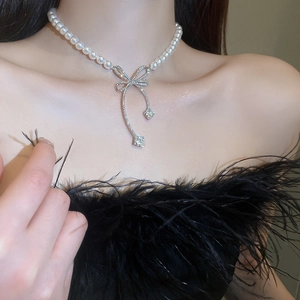 Collier ras du cou en perles élégant avec pendentif nœud en diamant sur un mannequin