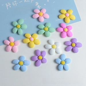 Flat lay of colorful matte resin flower charms for DIY hair clips and phone cases