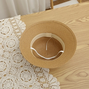Detailed view of the straw sun hat interior showing the sweatband and elastic chin strap