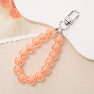 Close-up of peach bead-in-bead charm with silver metal lobster clasp for phone and bags