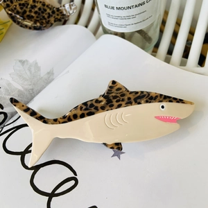 Detail of leopard print shark hair clip on a magazine showing glossy acetate texture