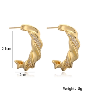 Detalle de pendientes dorados en forma de C con medidas de 2,1 cm y peso de 8 g