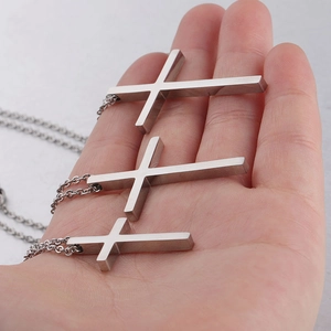 Detailed comparison of three sizes of minimalist polished stainless steel cross pendants
