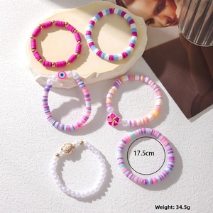 Detail view of colorful Heishi bead bracelets with turtle and evil eye charms