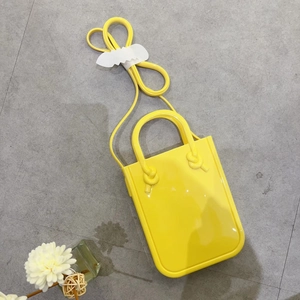 Detail shot of bright yellow mini PVC jelly bag with waterproof texture and handles