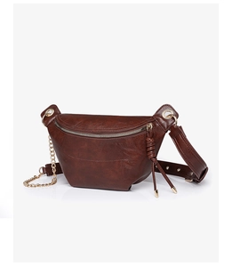 Detailansicht der braunen Leder-Satteltasche mit goldener Kette und verstellbarem Gurt