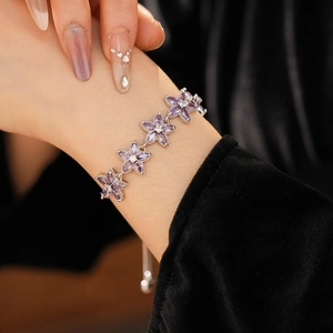 Details eines verstellbaren Silberarmbands mit lila Zirkonia-Blüten am Handgelenk