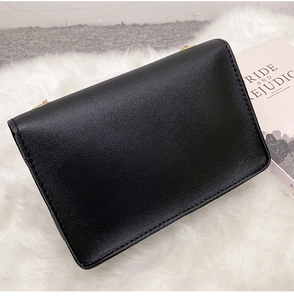 Detail of black leather flap crossbody bag with clean stitching and minimalist design