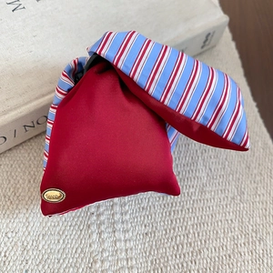 Close-up of red and blue striped satin hair claw clip with gold love tag
