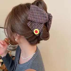 Plaid fabric bow hair clip with button detail for women stylish low ponytail look