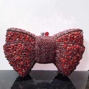 Close-up of red rhinestone bow evening clutch bag with sparkling crystal details