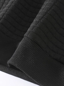 Close-up of black sweatshirt fabric with quilted patterns and high-density ribbed texture