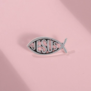 Silver metal Ichthys fish brooch pin with Jesus engraving on purple background