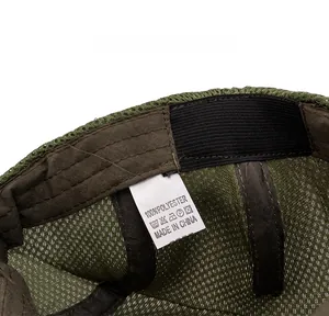 Close-up of mesh fabric texture and polyester care label inside the dark green cap