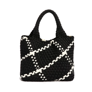 Woven black and white checkered large tote bag with top handles on white background