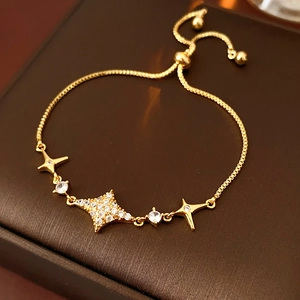 Detailed view of gold adjustable star bracelet with sparkling zircon inlays on a jewelry box