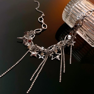 Macro shot of silver star-shaped pendant with sparkling rhinestone tassels and metal chain