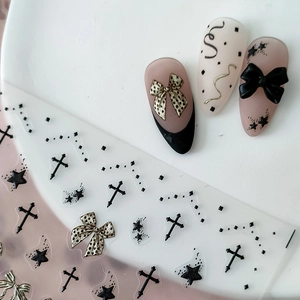 Nagelaufkleber mit Kreuz- und Sternmotiven sowie goldenen Schleifen auf Gelnägeln
