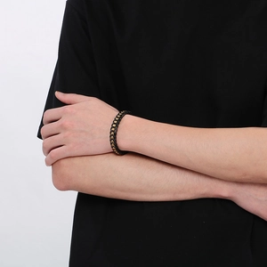 Men's braided black leather bracelet with gold magnetic clasp on model's wrist