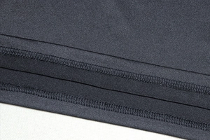 Close-up of high-quality double-needle stitching on black knitted crop top and mini skirt