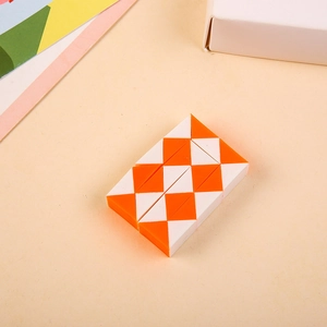Detail view of orange and white 24-section snake cube toy folded in a rectangle
