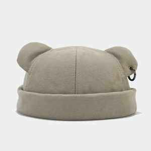 Detail of khaki docker hat featuring 3D bear ears and a black metal punk ring decoration