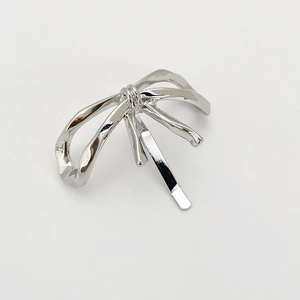 Close-up of a silver alloy bow-shaped hair clip with a minimalist twisted ribbon design