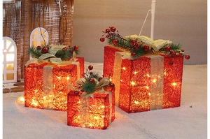 Close-up of red mesh Christmas gift boxes with warm LED lights and gold ribbon bows