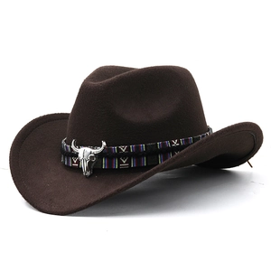 Brown felt western cowboy hat with ethnic bull skull band on a white background