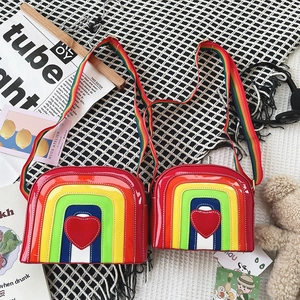 Detailed macro view of vibrant rainbow striped crossbody bags with a red heart patch