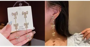 Detail of silver S925 butterfly drop earrings with white rhinestones on model