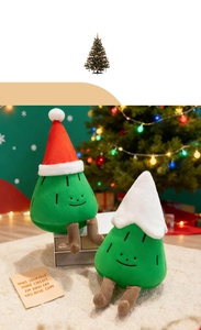 Close-up of cute Christmas tree plush toys with embroidered faces and red holiday hats